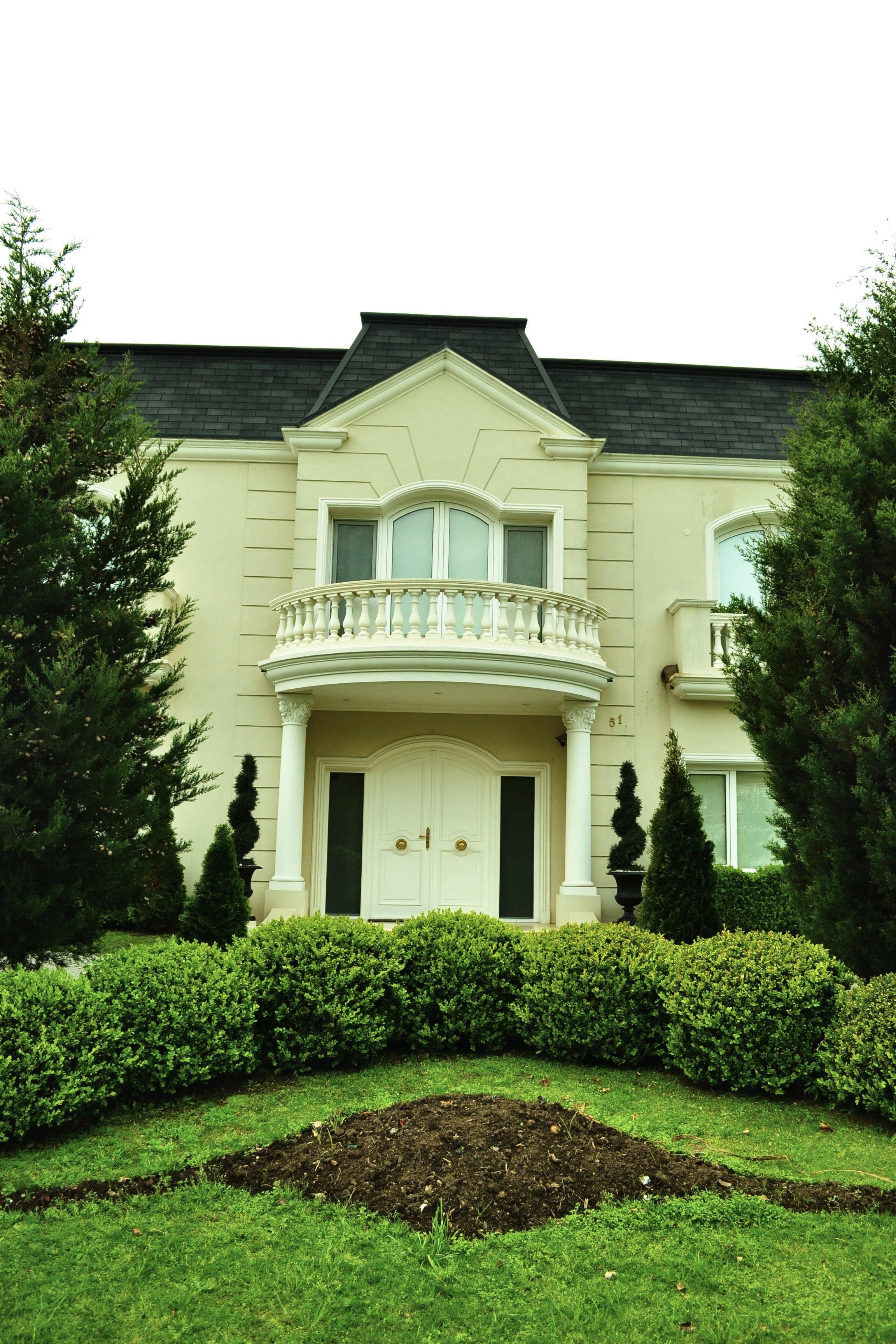 Fachada principal con pórtico y balcón curvo