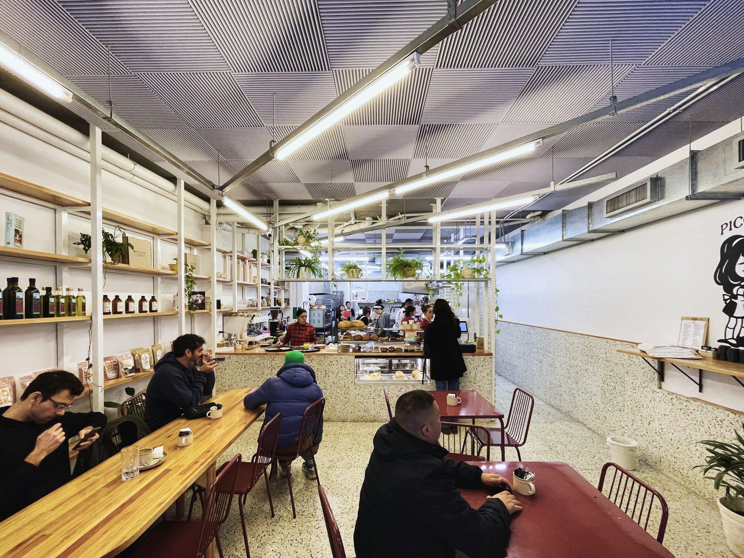 Salón principal hacia el fondo, con la barra corrida de madera y las mesas