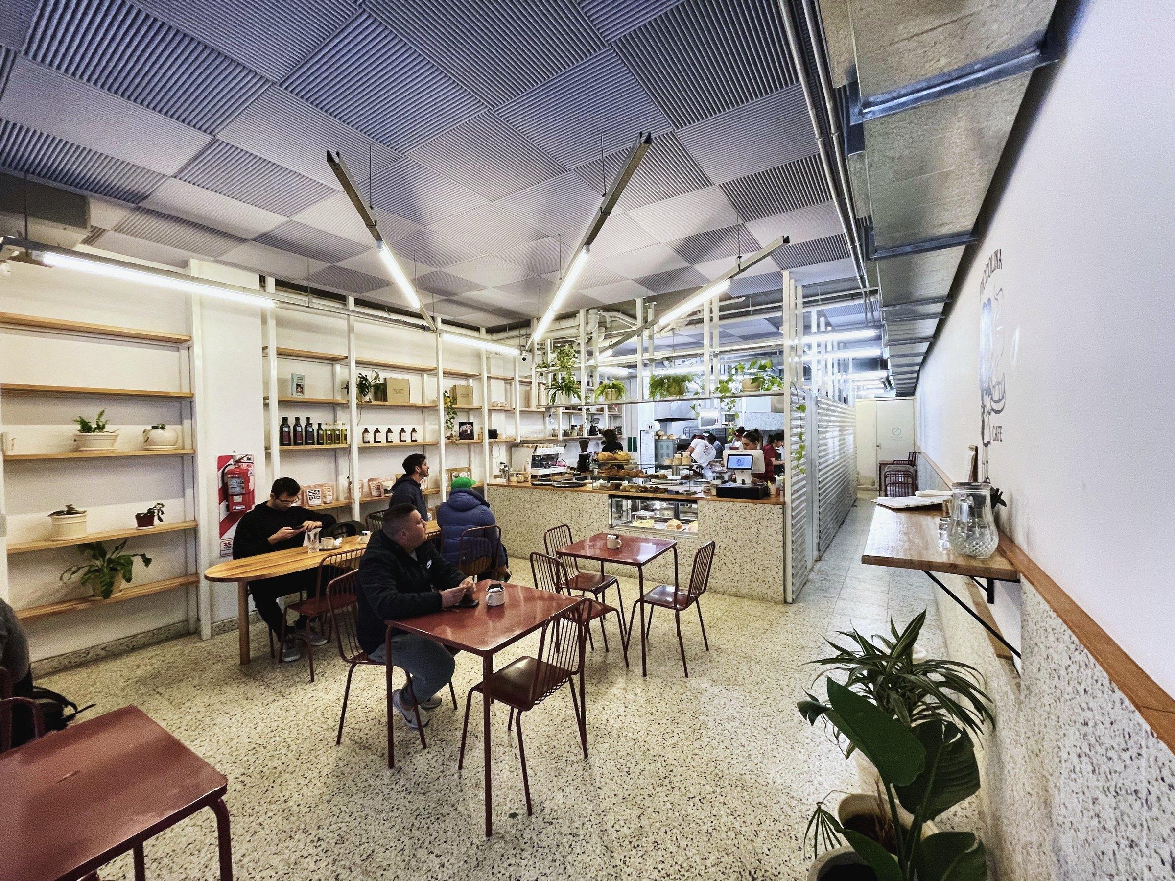 Salón con las estanterías de madera y la cocina abierta al fondo