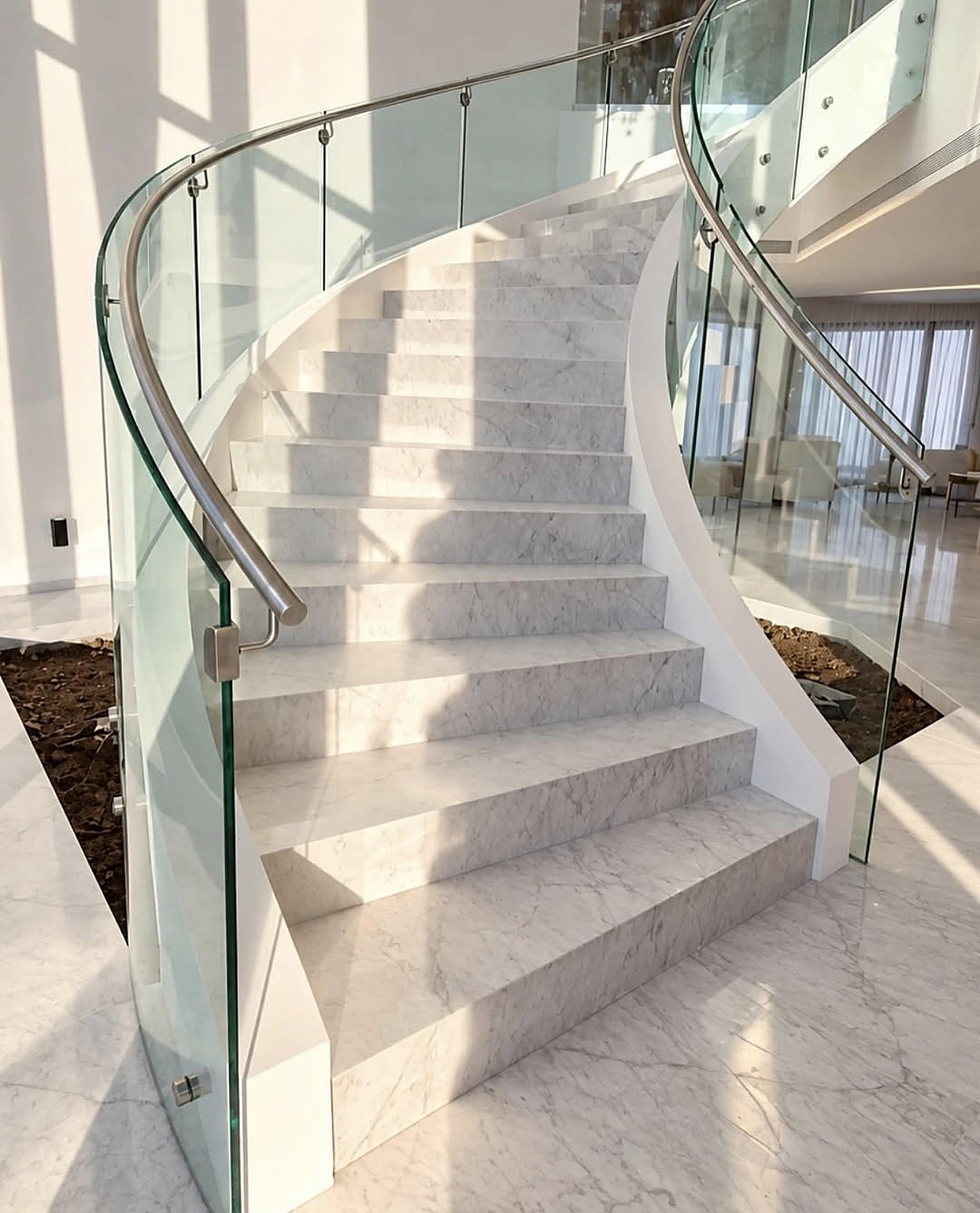 Escalera curva de mármol con barandas de vidrio, Casa MR