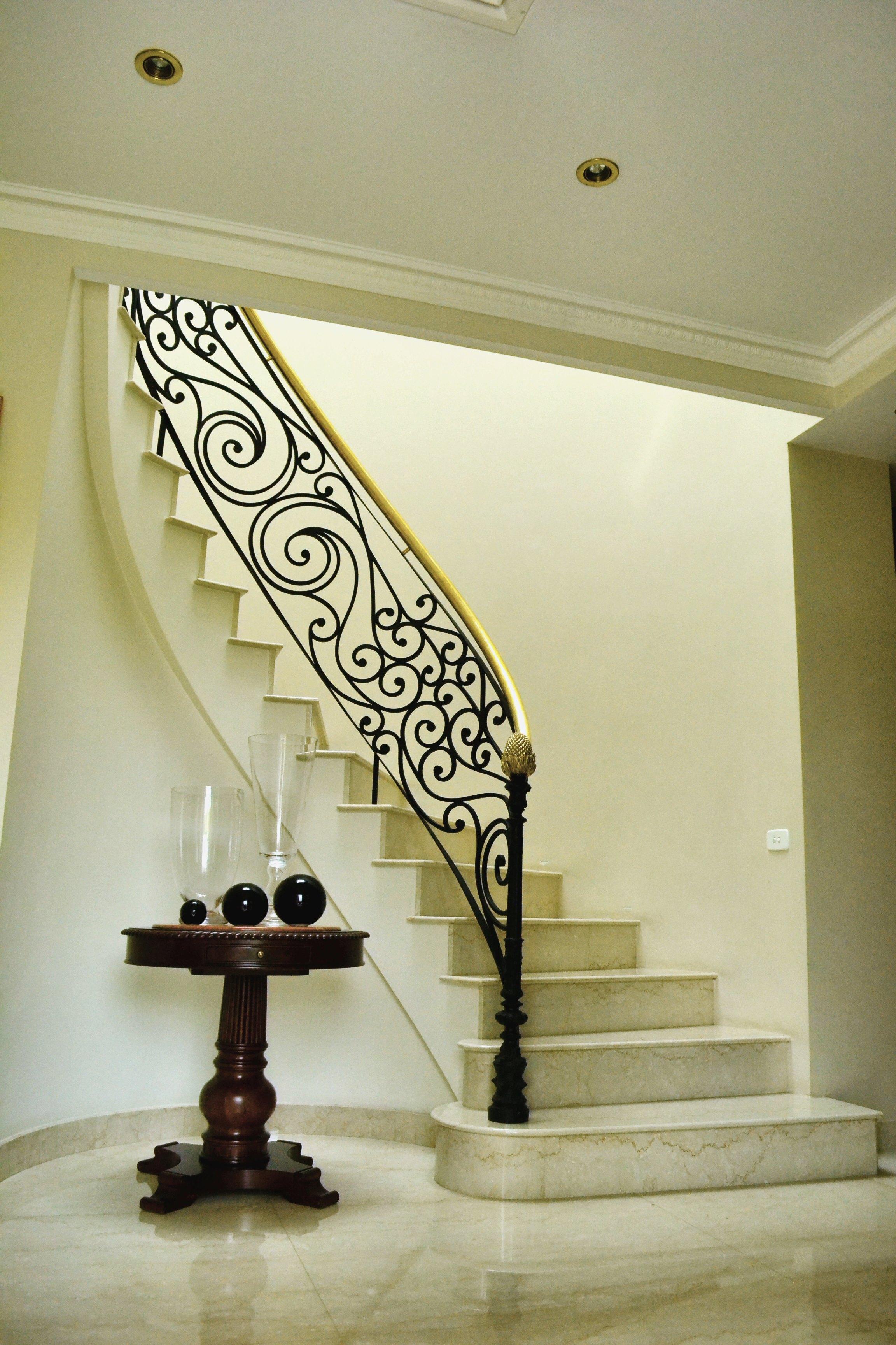 Escalera curva con baranda de hierro forjado
